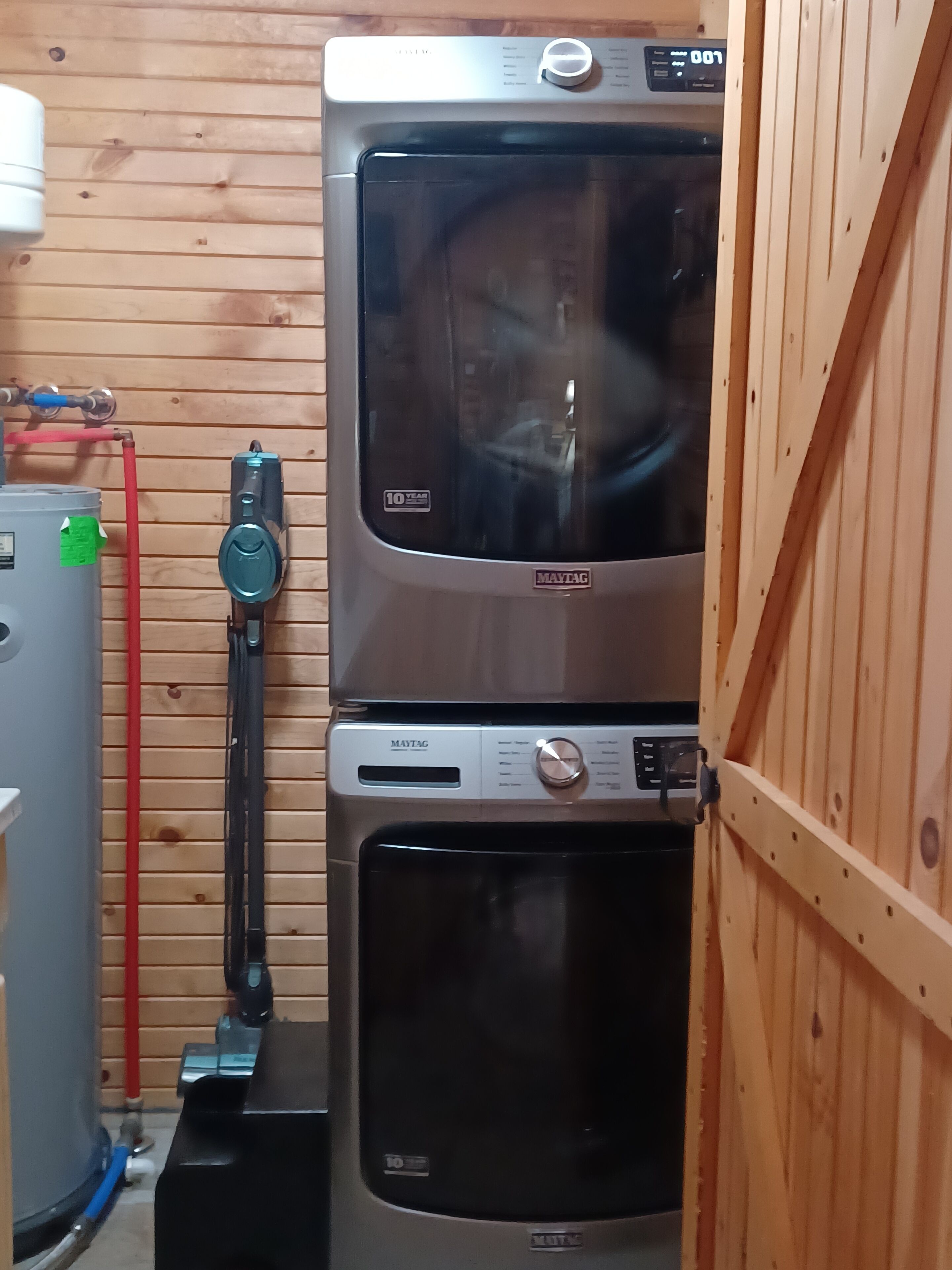 Una cocina compacta con horno empotrado, microondas, calentador de agua y estufa a gas.