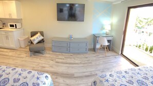 A hotel room with two beds, a desk, a TV, and a view of the outdoors. - Satellite Motel - License to Chill 115 (Treasure Island)