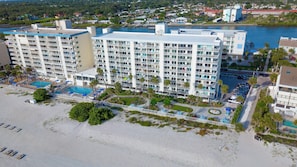 Un hotel de varios pisos con piscina, acceso a la playa y vistas del entorno.