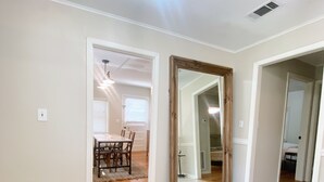 A spacious hallway with a round, striped rug, a ceiling light, and a door leading to a dining area. - PRIVATE Cleveland St. Cottage~Walk Folsom Village (Folsom)