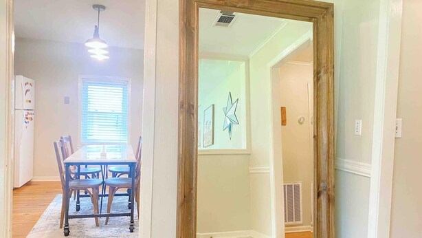 A dining area with a table and chairs, a ceiling light, and a window with blinds. - PRIVATE Cleveland St. Cottage~Walk Folsom Village (Folsom)