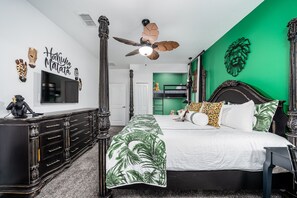 A bedroom with a four-poster bed, a ceiling fan, a TV, and a green accent wall. - 2-Story Slide & Disney Magic – The Ultimate Family Adventure Awaits! (Davenport)