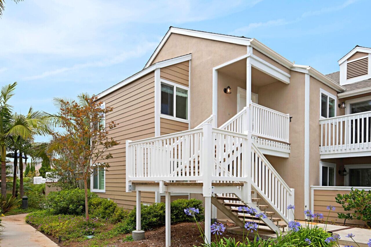 A two-story building with a balcony and a staircase.