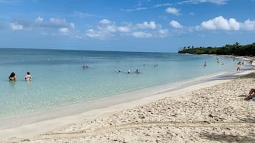 Ranta lähistöllä, aurinkotuoleja, rantapyyhkeitä