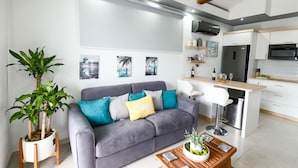 Un salon moderne avec un canapé gris, une table basse et une plante en pot.