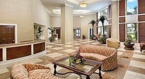 Relax in the spacious lobby area with a comfortable sofa and chairs arranged around a central coffee table.