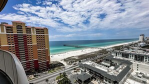 Un paysage urbain côtier avec une plage, une jetée et des immeubles de grande hauteur.