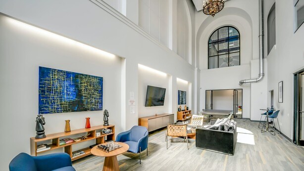 Eine geräumige Lobby mit hohen Decken, moderner Möblierung und Kunstwerken an den Wänden.