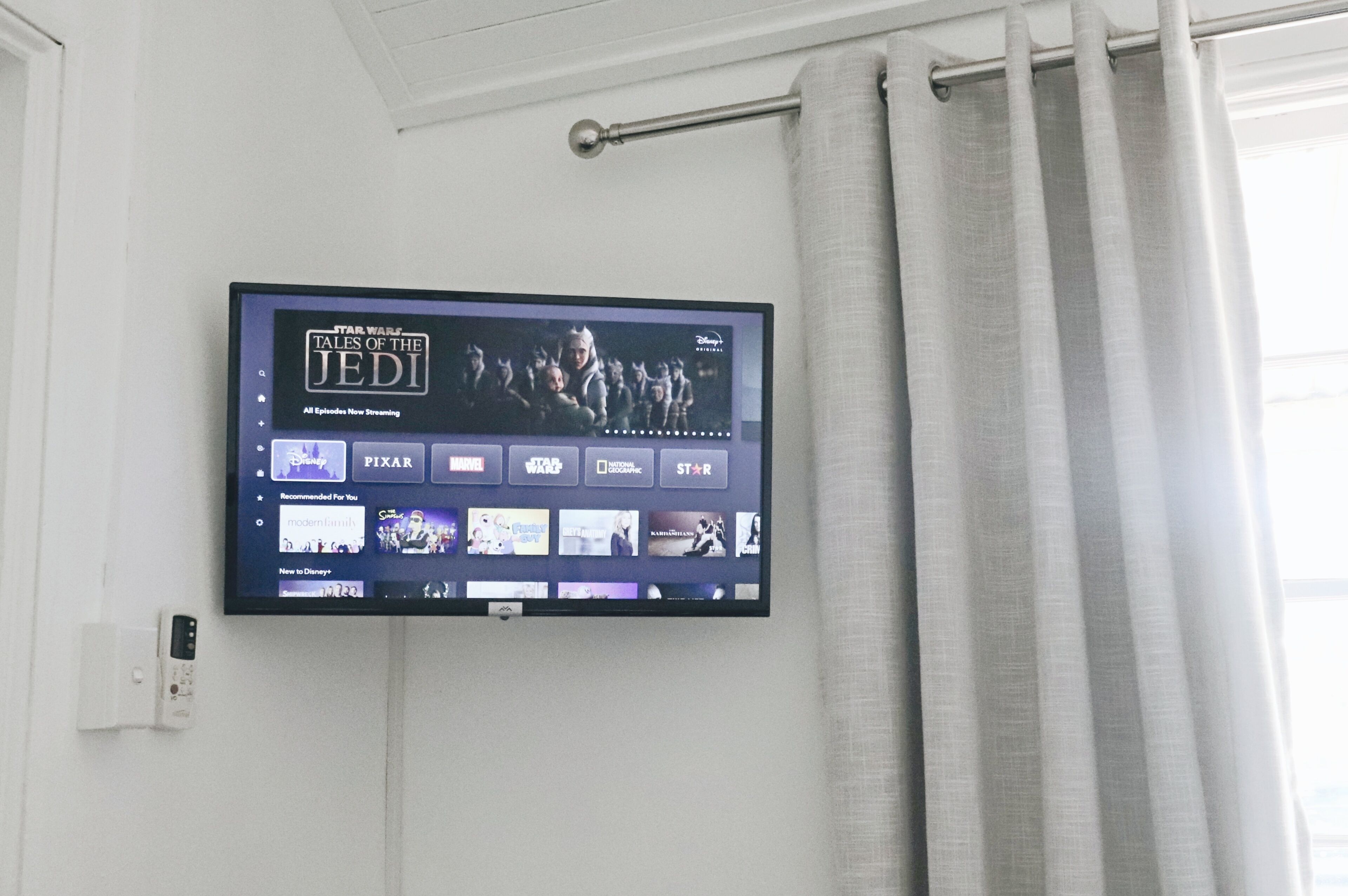A flat-screen TV mounted on a wall displaying the Star Wars Tales of the Jedi series.