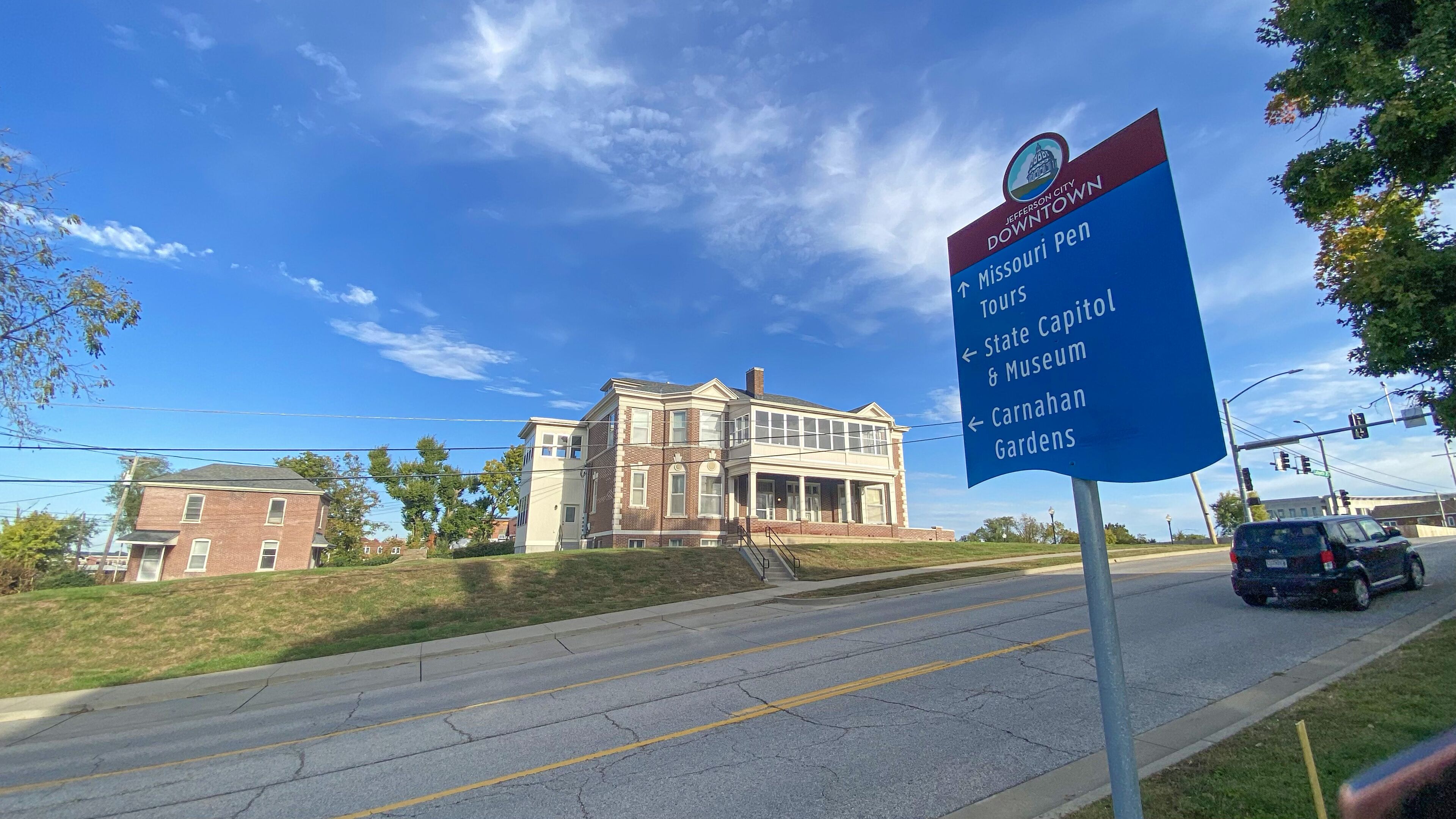 A signboard with directions to Missouri Pen, State Capitol & Museum, and Carnahan Gardens.