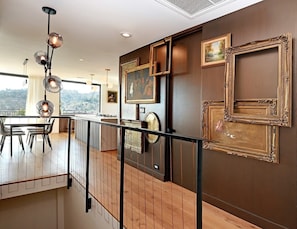 A modern interior with a dining area, a staircase, and a view of the outdoors.