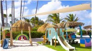 Ein Strandspielplatz mit Rutschen und einer Regenbogen-Dekoration.