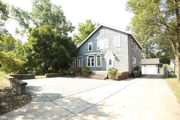 Ein zweigeschossiges Haus mit Vorgarten, Garage und Auffahrt.