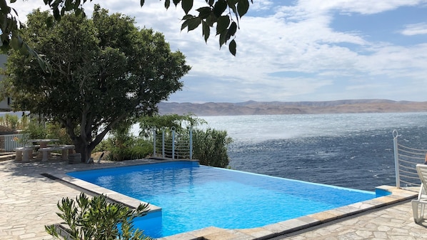 Une piscine avec vue sur la mer et les montagnes.