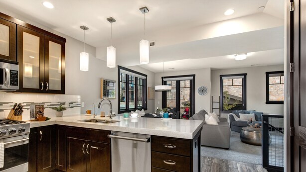 A modern kitchen with dark wood cabinets, stainless steel appliances, and pendant lighting. - Central Location, Hot Tub, Chef (Park City)