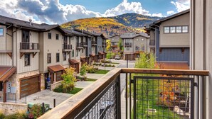 A row of townhouses with a mountain view, a paved walkway, and a small garden area. - Central Location, Hot Tub, Chef (Park City)
