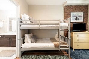 A bunk bed with a television and a framed picture on the wall.
