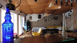 Relax in this inviting living room with a brick wall, woven ceiling, and comfortable seating.