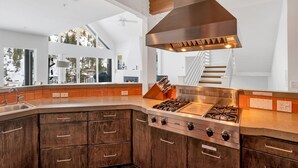A modern kitchen with a large island, stainless steel appliances, and a view of the outdoors. - Ski in/ski out to Alta in this bright, breathtaking new home that sleeps 12 with fireplace! (Alta)