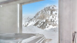 A room with a hot tub and a view of snow-covered mountains. - Ski in/ski out to Alta in this bright, breathtaking new home that sleeps 12 with fireplace! (Alta)
