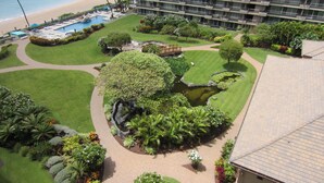 A hotel with a pool, a beach view, and a well-maintained garden with a pond. - Whaler Tower II - 1 Bedroom Condo with Beautiful Ocean View (Lahaina)