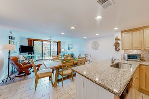 Relax in this spacious room with a dining area, comfortable seating, and a fully equipped kitchen.