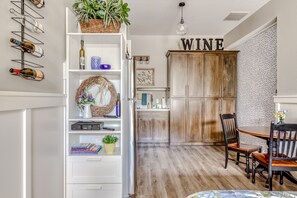 Enjoy a stylish kitchen and dining area with a wine rack, wooden cabinet, and dining table.