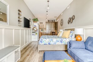A bedroom with a bed, a sofa, a desk, a mirror, a wardrobe, and a wall-mounted TV. - Beautifully-updated, ground floor studio with a kitchenette, & free WiFi (McMinnville)