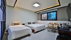 Une chambre d’hôtel moderne avec deux lits, un bureau et une chaise.