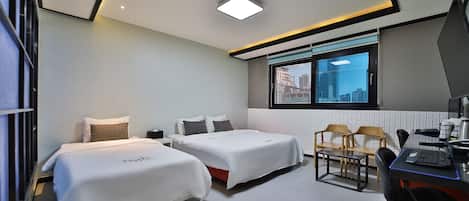 A modern hotel room with two beds, a desk, and a chair.