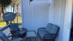 A covered outdoor seating area with wicker furniture and a satellite dish. - Birdie`s Bungalow on Fripp/Cards Avail/Golf Cart (Fripp Island)
