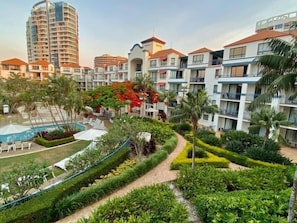 Un hotel con diversi edifici, una piscina e giardini curati.