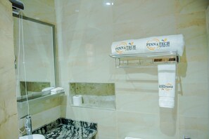 Une salle de bain dotée d’un lavabo en marbre, d’une douche en verre et d’un porte-serviettes avec des serviettes de la marque Pinnatech Suites Ltd.