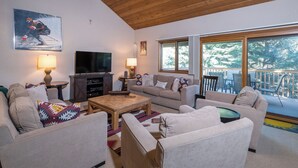 A cozy living room with a flat-screen TV, two sofas, a coffee table, and a wooden ceiling. - Cozy Family sized Condo- access to Pools and other Summer time Amenities (Sun Valley)