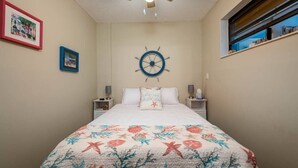A bedroom with a bed, a ceiling fan, a wall clock, and framed pictures. - Free Golf Cart Free Kayaks Steps to Pool Pickleball (Key Largo)