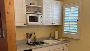 A compact kitchen with white cabinets, a microwave, a sink, and a stove. - Room 4️⃣- a beautiful studio in boutique hotel,  a few steps from Downtown PS 🌺 (Palm Springs)