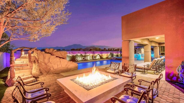An outdoor seating area with a fire pit, lounge chairs, and a poolside bar. - THE MASTERPIECE- Half Acre-8BR-5.5BA (Indio)