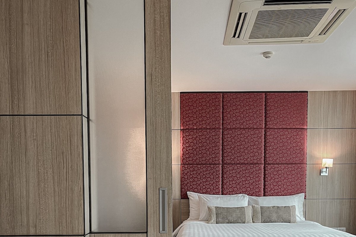 Un dormitorio moderno con cama, armario empotrado y rejilla en el techo.