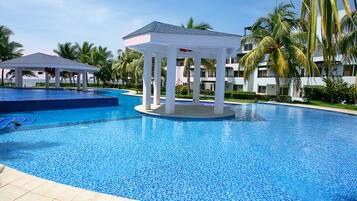 Una piscina con un pabellón y palmeras.