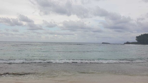 A beach with calm waves and a cloudy sky. - 3-Bed House Sleeps 6 with Mountain Views (Ocho Rios)