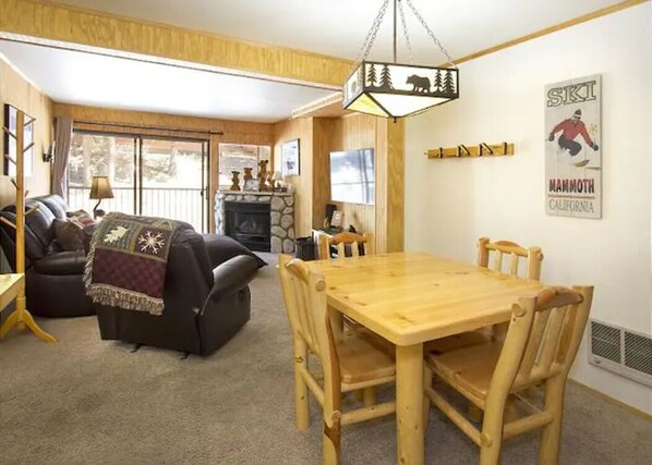 Ein gemütliches Wohnzimmer mit Kamin, Esstisch und Sofa.