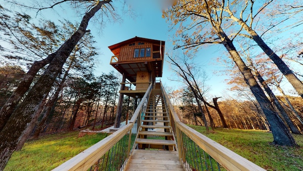 A wooden tower house with a staircase leading up to it, surrounded by trees. - 1 bed 1 bath Treehouse called the Firetower (Jackson)