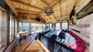 A cozy cabin interior with a large bed, a dining area, and a kitchen. - 1 bed 1 bath Treehouse called the Firetower (Jackson)