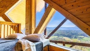 A bedroom with a wooden ceiling and a large window overlooking a valley. - 100-Mile Views: 3 King Suites I Hot Tub I Game Rm-Pool Table/Arcade/Air Hockey (Sevierville)