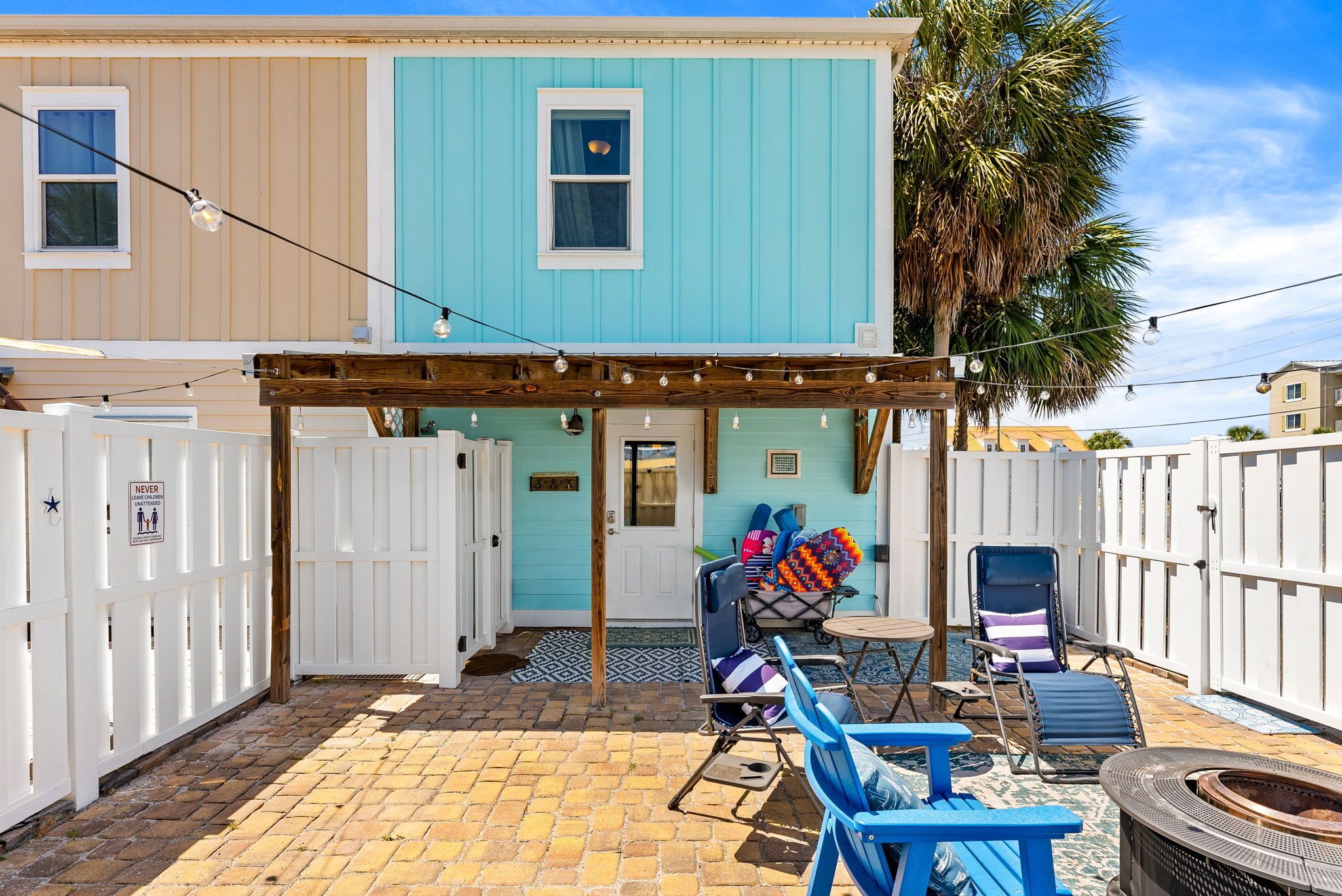 A patio area with a pergola, outdoor seating, and a fire pit.