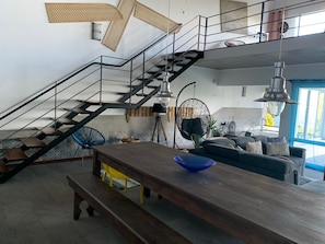A modern interior with a staircase, a dining area, and a seating area. - Pet-Friendly Villa Azores SunriseHouse with Sea View, Pool, Jacuzzi, Wi-Fi, Terrace & Garden (Pedreira)