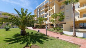 A multi-story hotel with balconies, a well-maintained lawn, and palm trees. - Penthouse with a fantastic view, Mountain View, Sea View, Terrace & Garden (La Cala de Mijas)