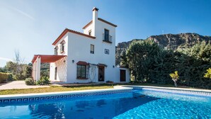 Un bâtiment blanc à deux étages, avec une piscine devant.