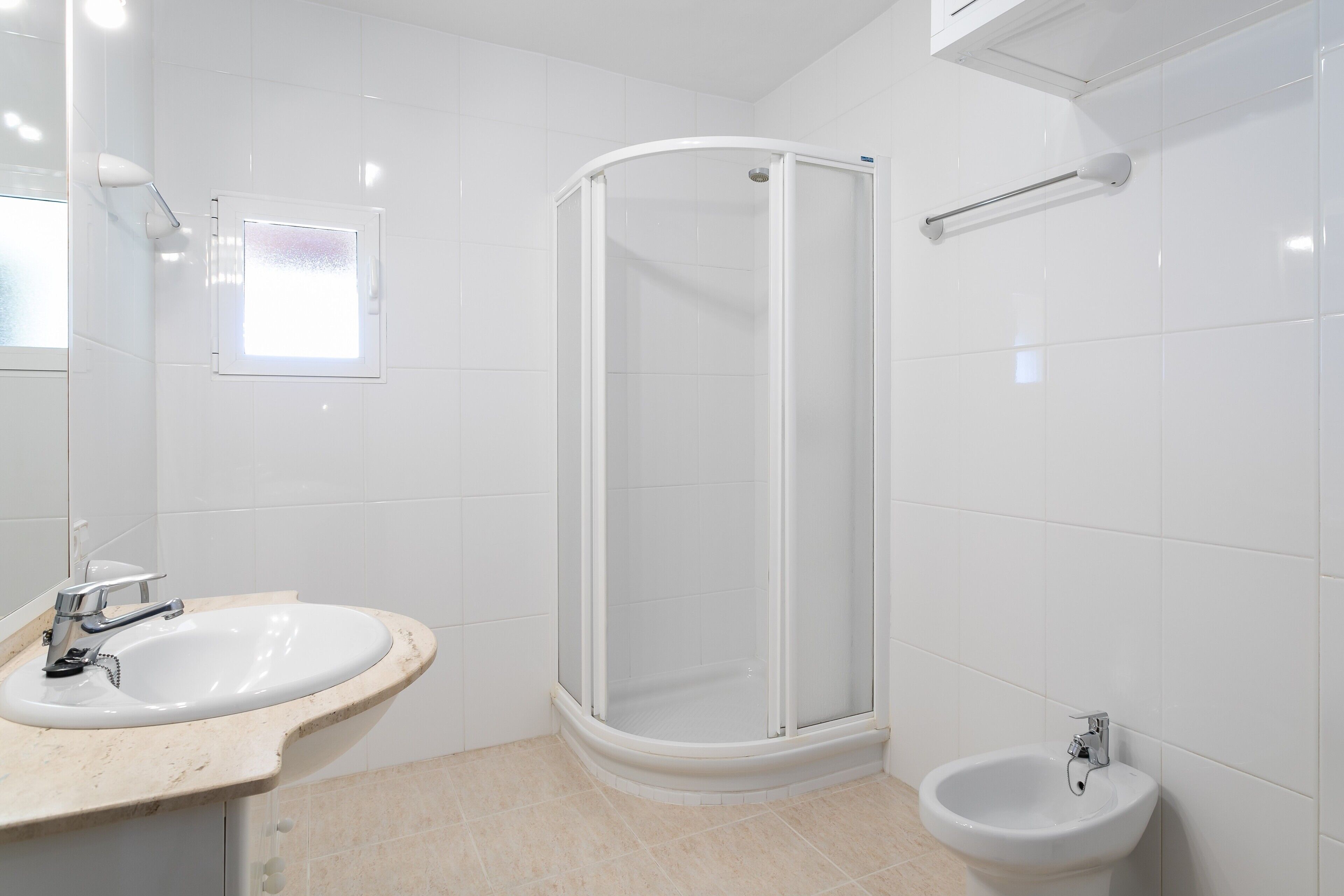 Un baño con lavamanos, cabina de ducha e inodoro con bidé.