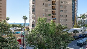 Un immeuble de grande hauteur doté de nombreux balcons, d’une piscine et offrant une vue sur l’océan.